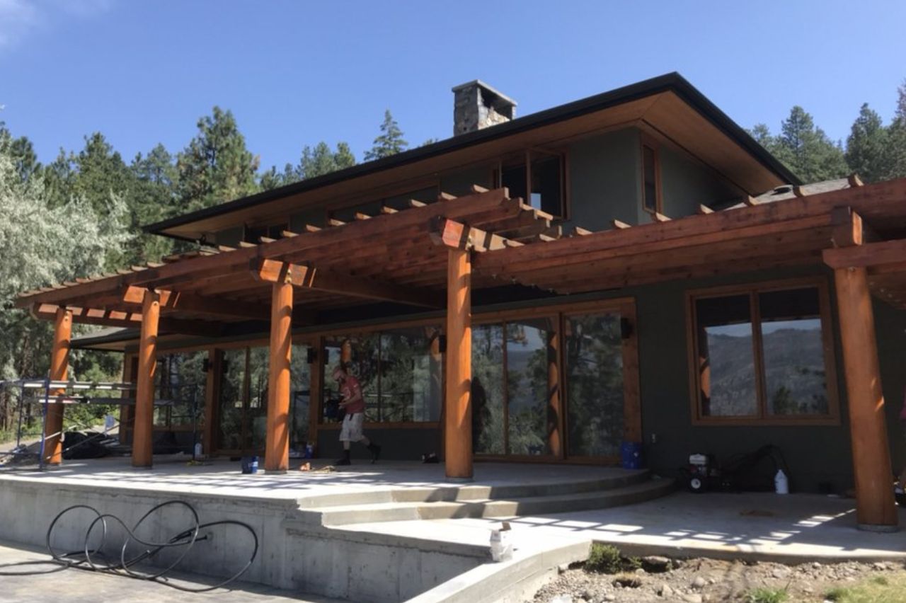 Elegantly stained wooden patio structure in a residential setting in the Okanagan.